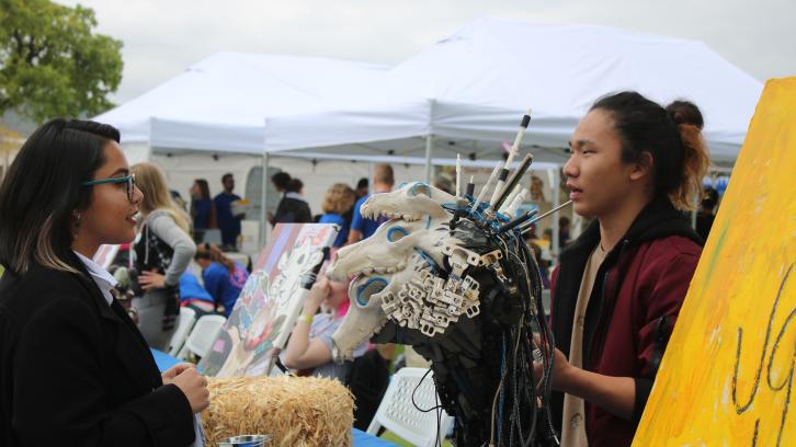 Student discusses their artwork at a MakerFaire event.